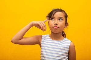 Asian child has an idea. Japanese child pointing to the head. Had a great idea. Japanese child thinking. photo