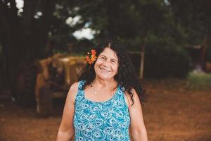 retrato de una bella y sonriente mediana edad. maduro. agricultora mayor. mujer en la granja en día de verano. actividad de jardinería. mujer brasileña. foto