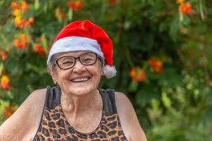 mujer mayor en sombrero de santa smilling. foto