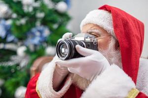 Santa Claus holding vintage camera. Portrait Isolated on yellow background. photo