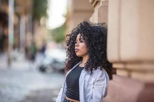 Beautiful Brazilian girl with curly hair on street. Life in big cities. photo