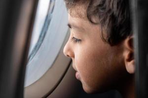 Boy looking out of airplane window photo