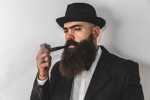 Stylish bearded man smoking pipe. photo