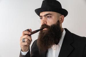 Stylish bearded man smoking pipe. photo