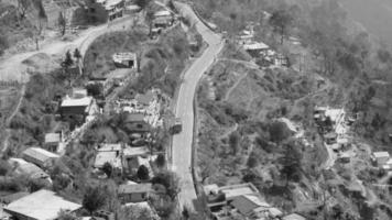 bovenaanzicht vanuit de lucht van verkeersvoertuigen die rijden op bergwegen in nainital, uttarakhand, india, uitzicht vanaf de bovenzijde van de berg voor verkeer van verkeersvoertuigen zwart en wit video