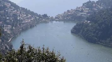 volledig zicht op het Naini-meer tijdens de avond in de buurt van Mall Road in Nainital, Uttarakhand, India, prachtig uitzicht op bergen en blauwe lucht aan de kant van het Nainital-meer video