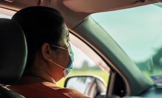 phichit, tailandia, 24 de julio de 2020: mujer con mascarilla sentada en un automóvil foto