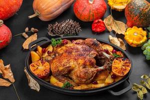 Baked chicken with potatoes, orange and dogwood berries. Background for autumn holidays photo
