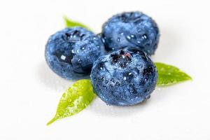 Three blueberries with leaves close-up photo
