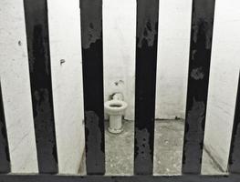 celda de alcatraz con rejas y sanitarios higiénicos foto