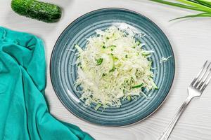 Top view fresh coleslaw in plate on white wooden background with fork photo