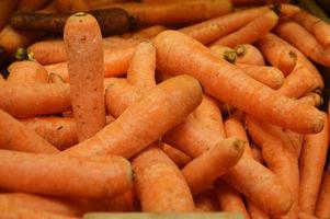 zanahorias naranjas frescas en el mostrador de la tienda. antecedentes. verduras, cosecha. comida vegetariana foto