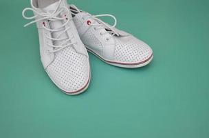 Fashionable white sneakers on a colored background. Shoes for walking, running, walking. Modern shoes. Free space for text. photo