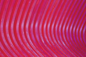 Trendy abstract pattern of wooden slats, wood texture painted in burgundy. Glare of the Sun on a curved surface, a beautiful color gradient. photo