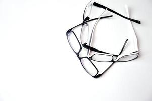 Glasses in a black frame with lenses for vision correction lie on a white background. Optics, ophthalmology, medicine. Free space for text photo