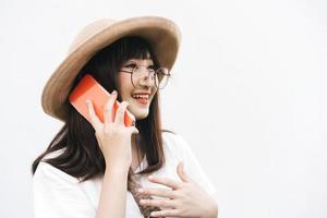 una chica asiática con gafas hace una llamada telefónica y habla con un amigo.