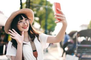 Young asian influence girl traveling in bangkok with smartphone for upload to social network. photo