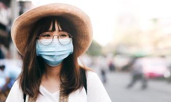 Young asian cute traveller wear mask protect virus covid for new normal lifestyle. photo