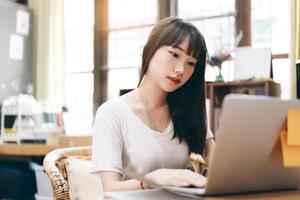 Cute asian teenager woman using laptop for study online. photo