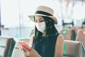 Escaneo de identidad joven adulta asiática viajera usa cara y máscara en la terminal del aeropuerto foto