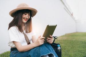 Young asian smile girl wear glasses tourism with modern technology trip. photo