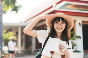 Young asian cute glasses teenager girl traveller backpack solo local travel with memo written daily. photo