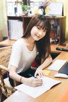 Asian teenager woman stay at home use internet for work and study photo