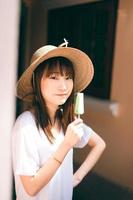 Portrait of cute asian teenager woman eating ice cream at outdoor garden. photo