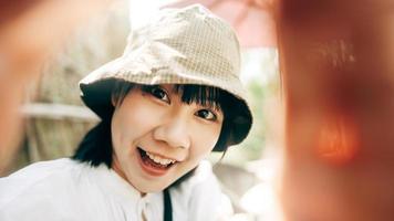 vista pov retrato de mujer asiática adulta joven tomar una foto selfie.