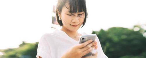 Young adult asian business woman using mobile phone application on day. photo