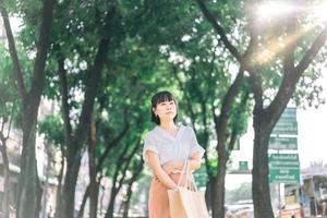 Young adult business asian woman walking in public park outdoor photo