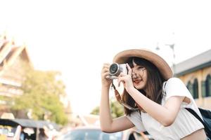 feliz joven mujer asiática mochila viaje local y toma una foto con la cámara.