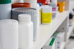 Bottles of pills arranged on shelf at drugstore photo