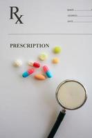 Pills and stethoscope on a prescription photo