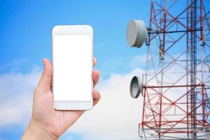 hand hold smartphone with telecommunication tower photo