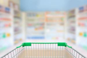 blur shelves of drugs in the pharmacy with shopping cart photo