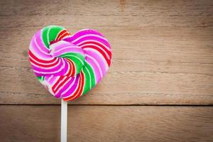colorful heart lollipop on wood background photo