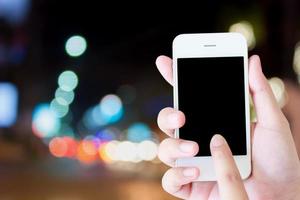 Business concept, hand holding mobile with traffic light blurred background photo