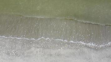 aérien lentement regarder vers le bas la douce vague d'eau a frappé la mer video