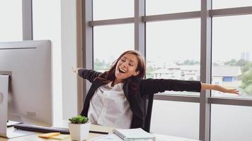 Happy caucasian business woman wearing a black suit Sit in front of a computer screen at workplace desk, relaxed and smiling. photo