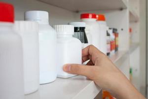 hand of woman pharmacist hold medicine bottle in the pharmacy photo