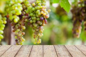 piso de madera con racimos de uvas de vino foto