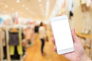 mujer usando celular en tienda de ropa foto