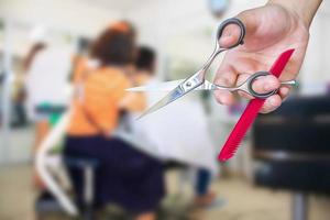 Hairdresser hold scissors with salon beauty background photo