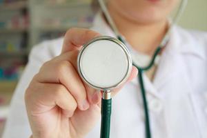 female doctor in white uniform holding stethoscope photo