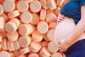 pregnant woman with medication tablets and pills photo