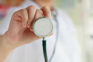 female doctor in white uniform holding stethoscope photo