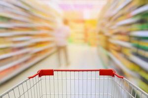 Supermarket aisle with empty shopping cart photo