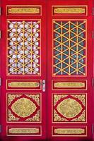 antigua puerta de madera roja china con talla dorada de dragón del templo chino foto