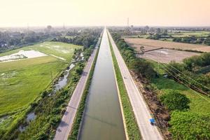 Aerial view of straight irrigation canal system management among the rice field and agronomic in countryside photo